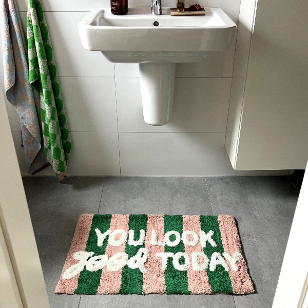 Tilføj et strejf af humor og farve til dit badeværelse med denne stilfulde bademåtte. Med teksten "You look good today" i smukke, livlige farver bliver det et statement-piece, der både er praktisk og dekorativt. Perfekt til at skabe en hyggelig og personlig stemning i badeværelset.