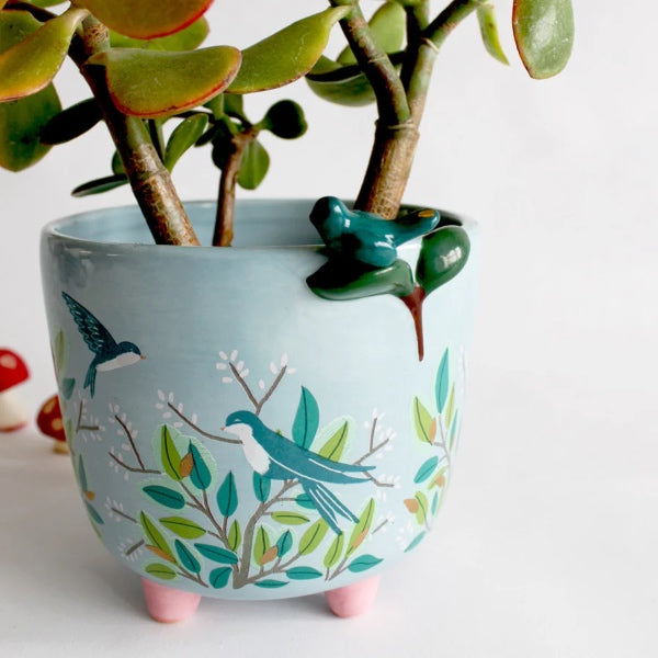 En meget yndig urtepotte med en porcelæns fugl, der kigger ud over toppen af urtepotten. Den har et farverigt bladmønster og søde detaljer og har god plads til din yndlingsplante.  Urtepotten er den perfekte gave til plantetossen og den kommer i en smuk æske med kært tryk på. 